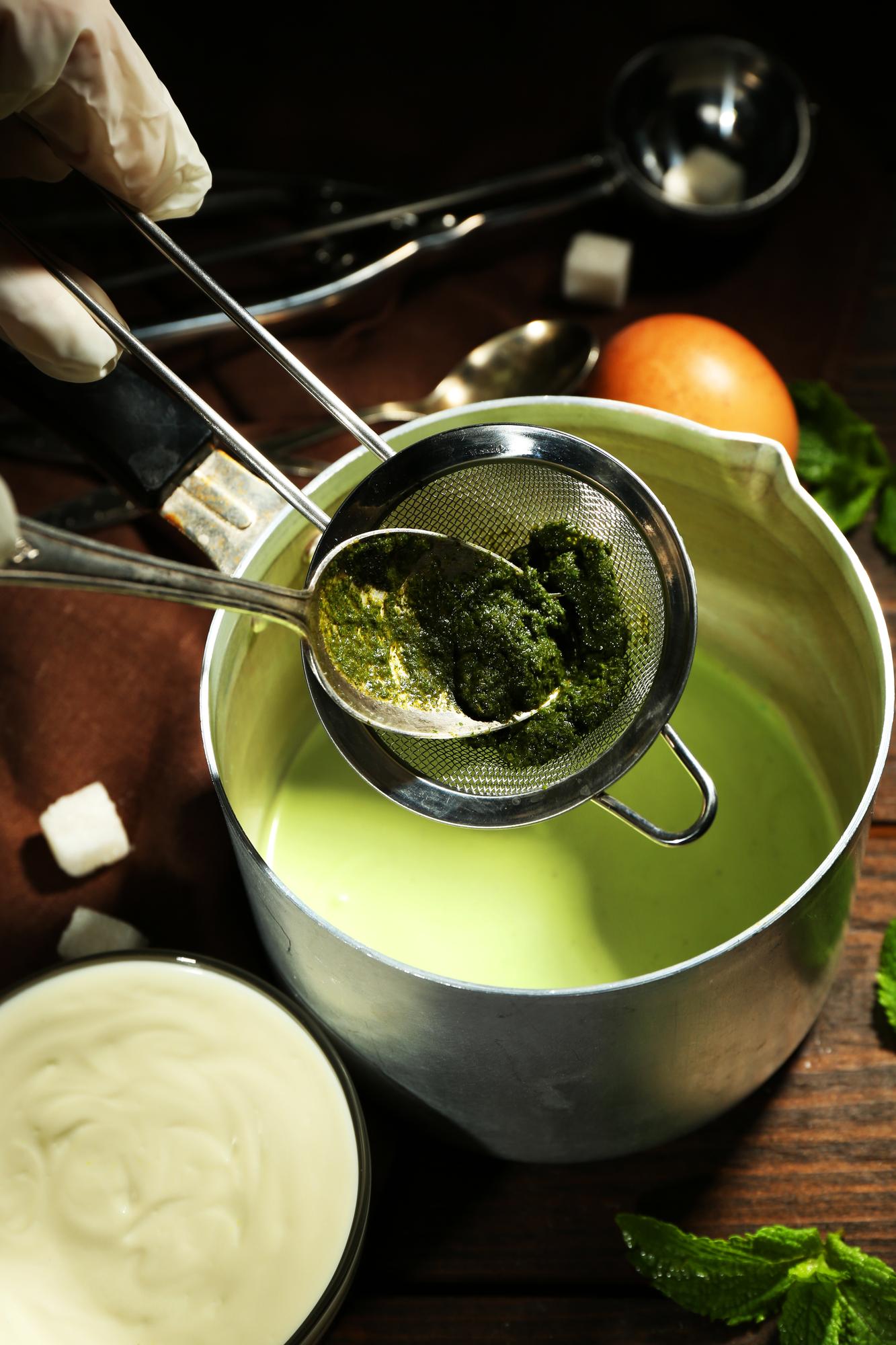 Pan with simmering sauce and herbs